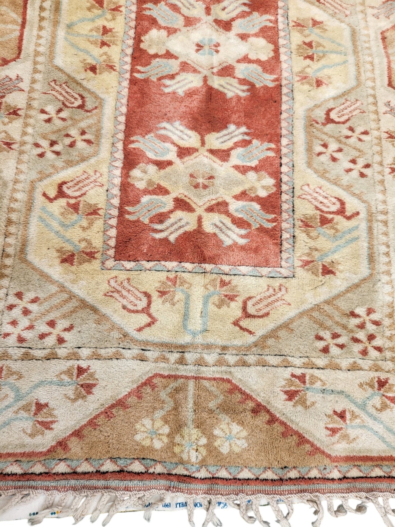 Handmade Turkish Milas wool rug measuring 120cm x 206cm. Central Salmon panel having three diamond shaped medallions