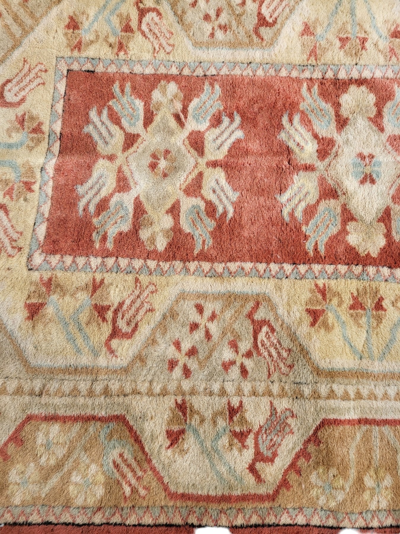 Handmade Turkish Milas wool rug measuring 120cm x 206cm. Central Salmon panel having three diamond shaped medallions