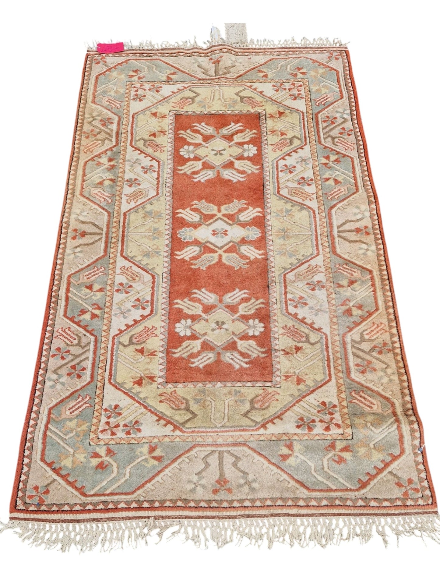 Handmade Turkish Milas wool rug measuring 120cm x 206cm. Central Salmon panel having three diamond shaped medallions