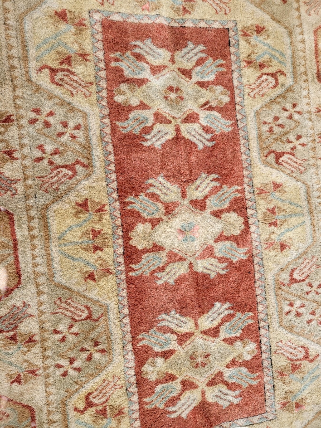 Handmade Turkish Milas wool rug measuring 120cm x 206cm. Central Salmon panel having three diamond shaped medallions