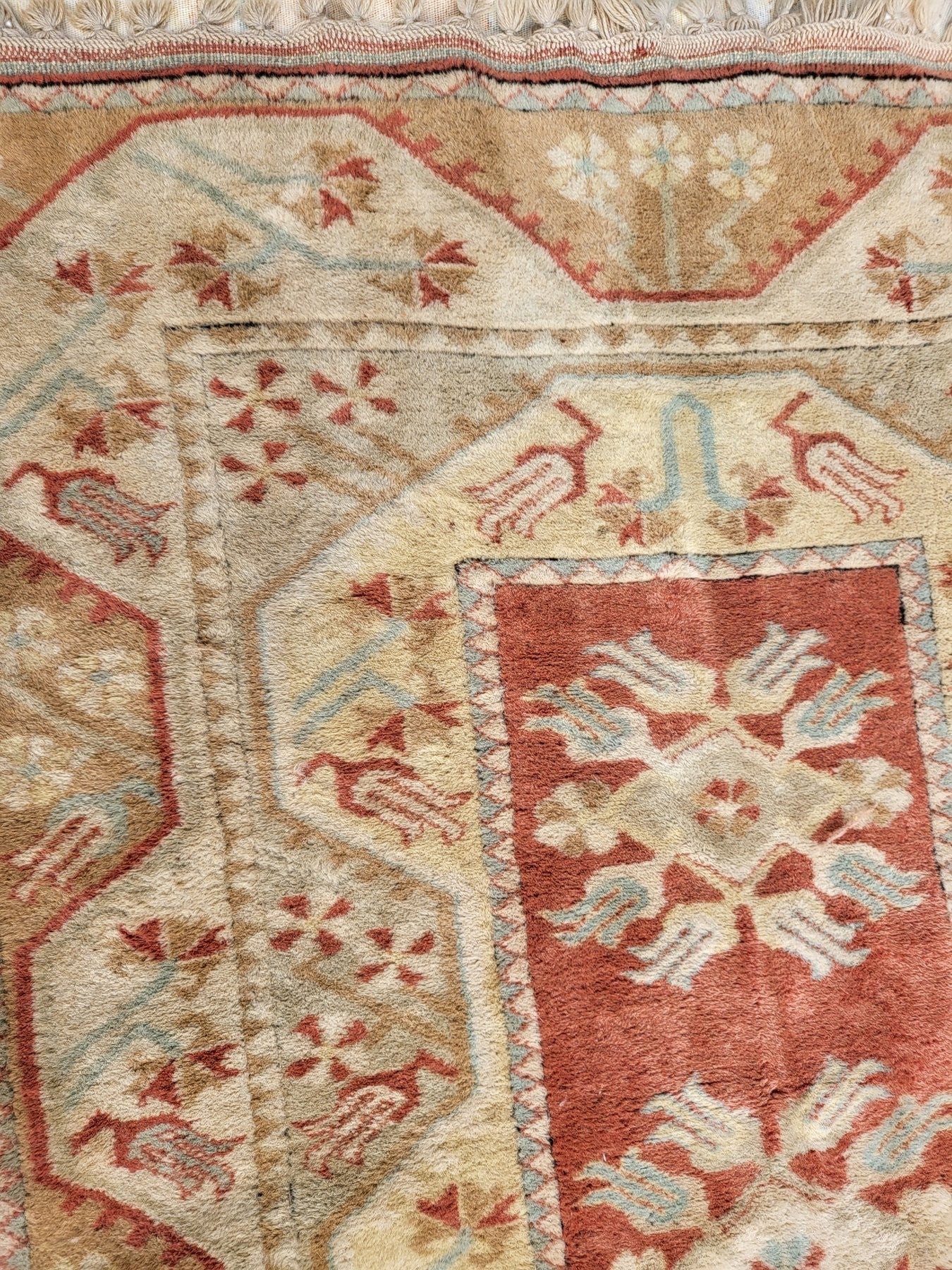 Handmade Turkish Milas wool rug measuring 120cm x 206cm. Central Salmon panel having three diamond shaped medallions